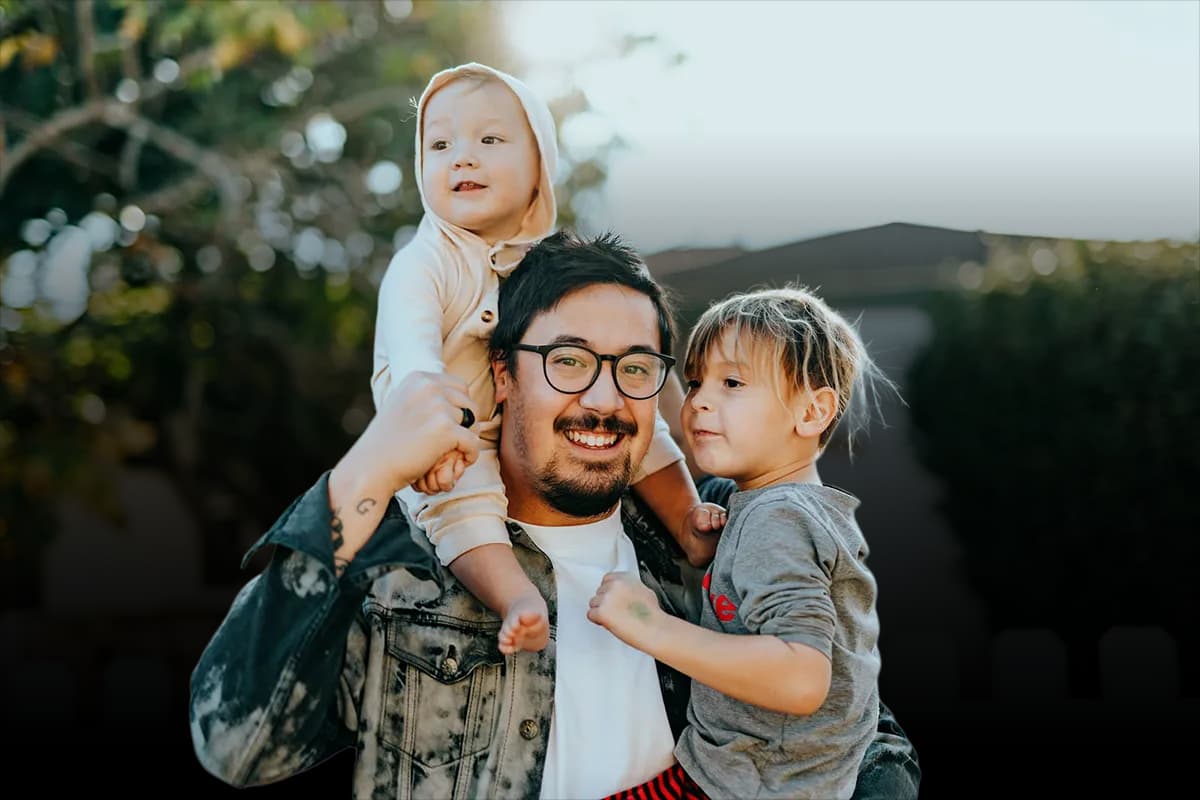 A father with his children smiling outdoors